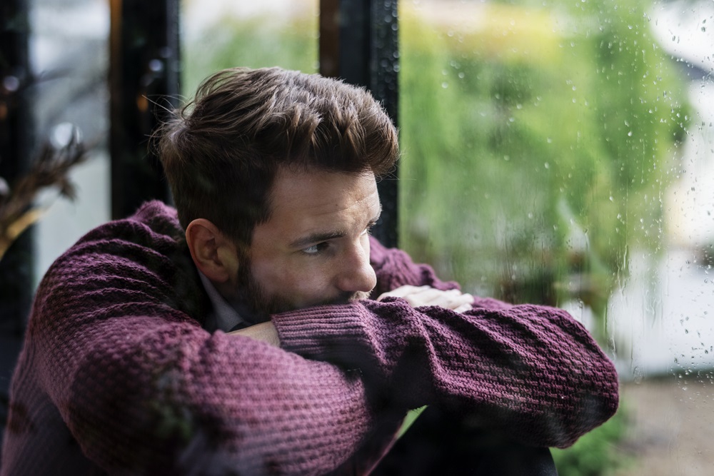 thoughtful man looking out the window