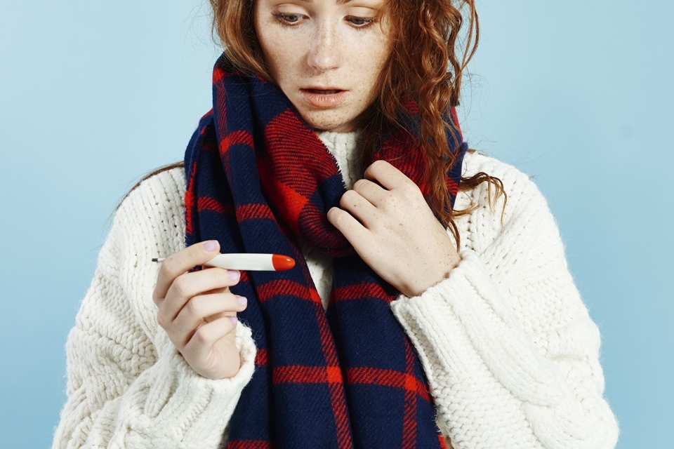 shocked woman with digital thermometer checking temperature