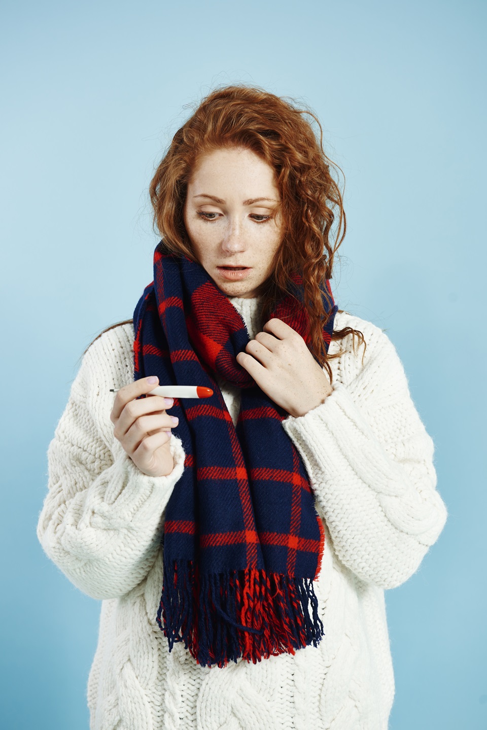 shocked woman with digital thermometer checking temperature