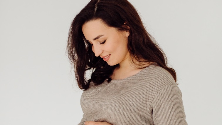 beautiful young pregnant woman posing in studio in dress