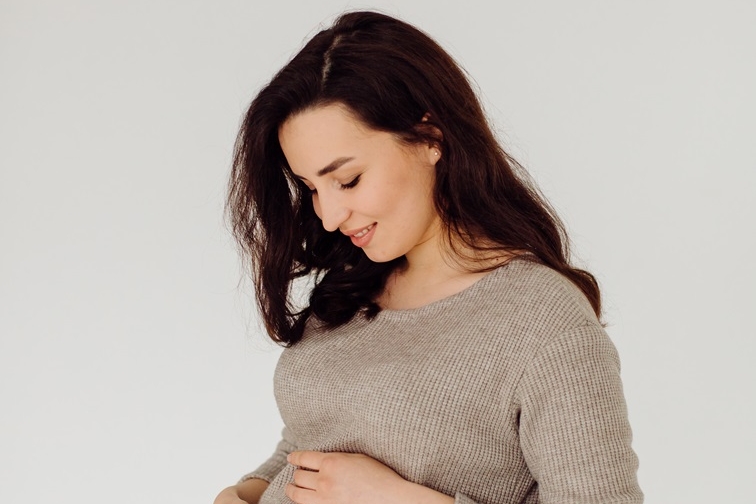 beautiful young pregnant woman posing in studio in dress