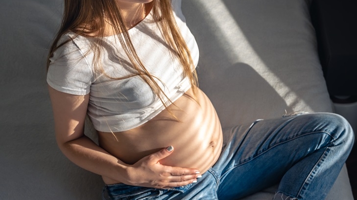 pregnant woman on the bed in the room on a sunny morning.