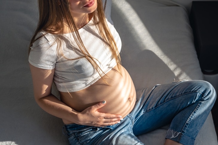 pregnant woman on the bed in the room on a sunny morning.