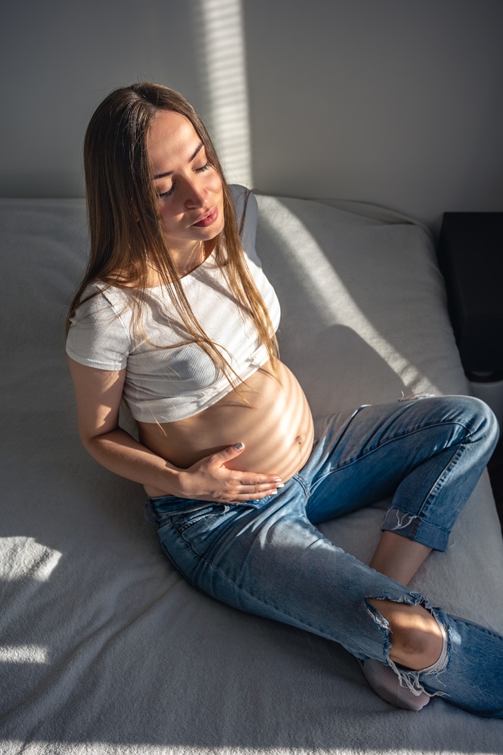 pregnant woman on the bed in the room on a sunny morning.