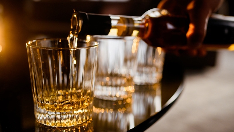 barman filling glass of alcohol