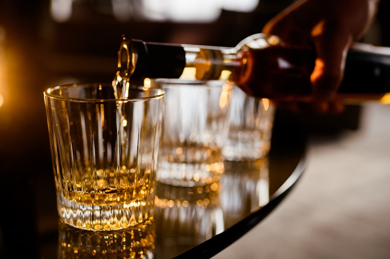 barman filling glass of alcohol